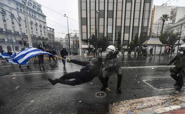 Un policía carga contra un manifestante, en Atenas.