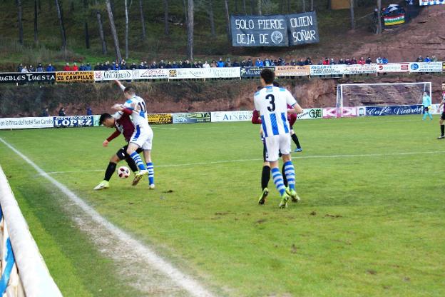 El blanquiazul Pablo trata de superar al visitante Ibáñez, mientras su compañero Arturo controla los movimientos de otro rival.