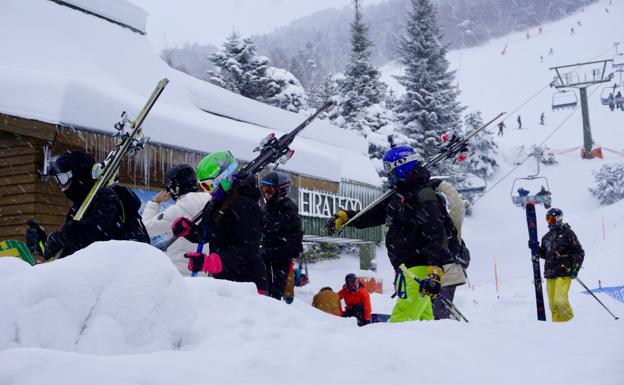 Aficionados portando sus esquís en el centro de Baqueira