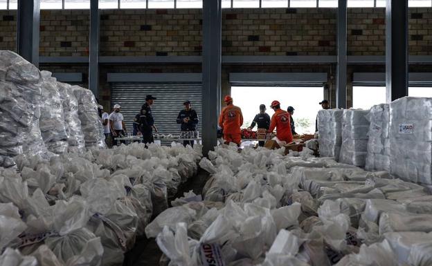 Protección civil junto productos de ayuda humanitaria almacenados en el punto de acopio del puente internacional de tienditas. 