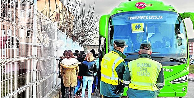 Los agentes de la Guardia Civil de Tráfico inician el control del transporte escolar a la llegada de los autobuses al instituto Tomás y Valiente en Fuenmayor. 