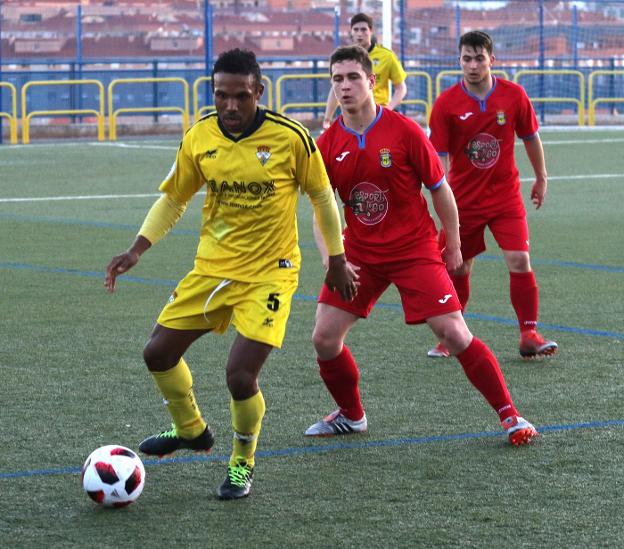 Jair protege el balón ante la defensa del Calasancio. 