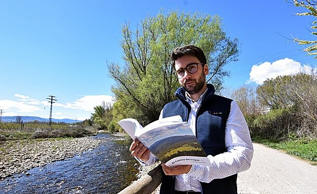 El camerano Álvaro González Martínez posa con su libro junto al río Iregua. :