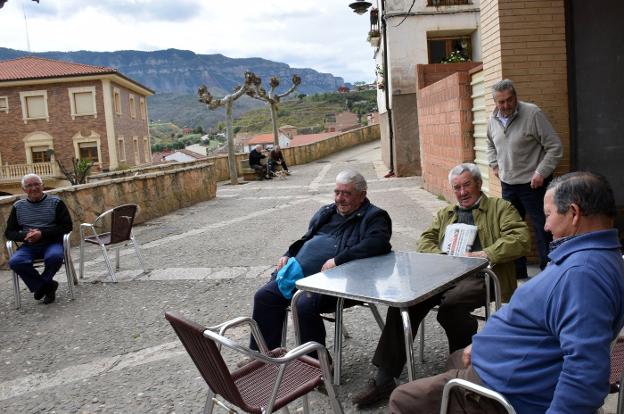 Julio Ruiz, Isaías Nicolás, Benito Álvarez y Pedro Sáenz conversan en la terraza. Al fondo, en el banco y con la perra Niebla, Felipe Santolaya y Primo Romanos. 