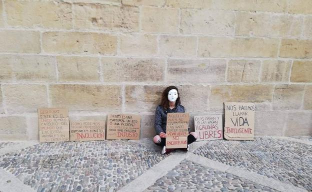 Una mujer protesta junto a la catedral de Santo Domingo contra el encierro del gallo y la gallina