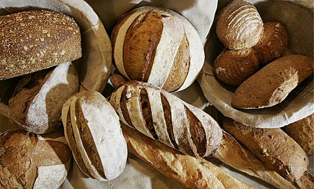 Barras y hogazas de pan de distintas harinas. :
