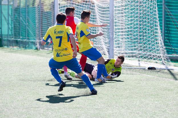 Víctor Pradas bloca el balón ante la presencia amarilla .