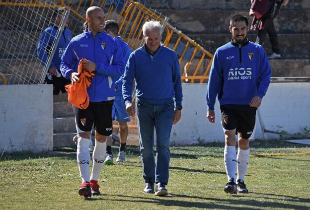 Miguel Sola salta al campo conversando con técnicos rivales.