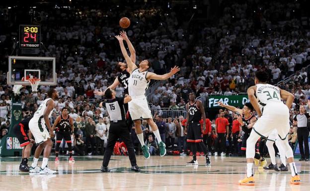 Marc Gasol, de los Toronto Raptors, y Brook Lopez, de los Milwaukee Bucks, saltan para dar el primer golpe en uno de los partidos de los Playoffs de la NBA de 2019.