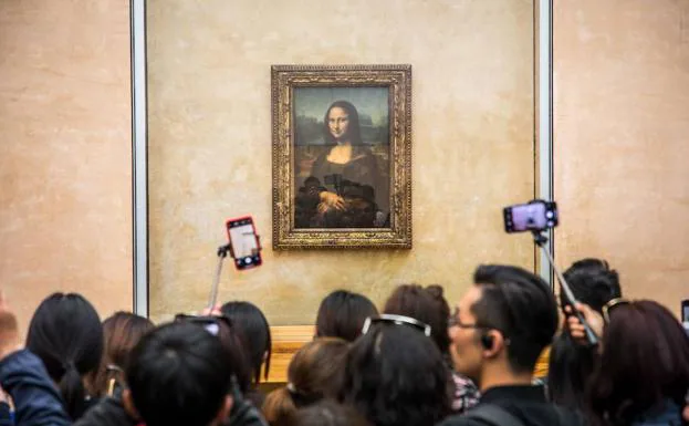 Un grupo de visitantes trata de fotografiar 'La Gioconda'.