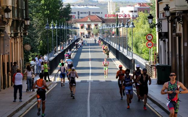 Los triatletas afrontan el segmento de carrera por el puente de hierro . 