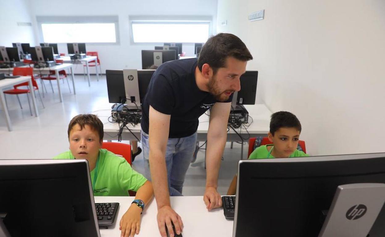 David Peso, coordinador del II Campus Tecnológico, este martes junto a dos de los niños participantes en el curso de verano.