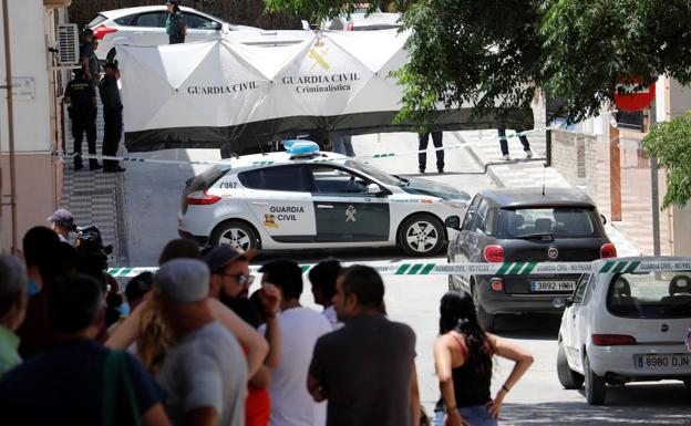 Agentes de la Guardia Civil despliegan una lona para tapar el traslado del cuerpo sin vida de la mujer de 42 años asesinada presuntamente por su marido en su vivienda de la localidad cordobesa de Rute.