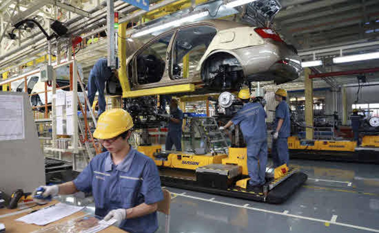 Trabajadores en una cadena de montaje en la fábrica de automóviles Geely en Ningbo (China). 