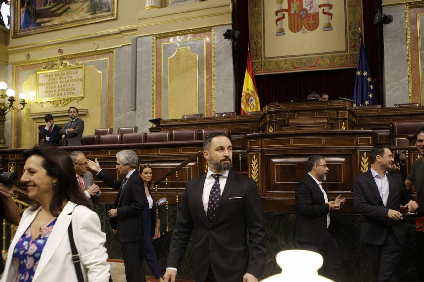 Santiago Abascal se dirige a su escaño al inicio de la sesión, mientra Aldolfo Suárez Yllana (detrás a la izquierda) dialoga con otro diputado.