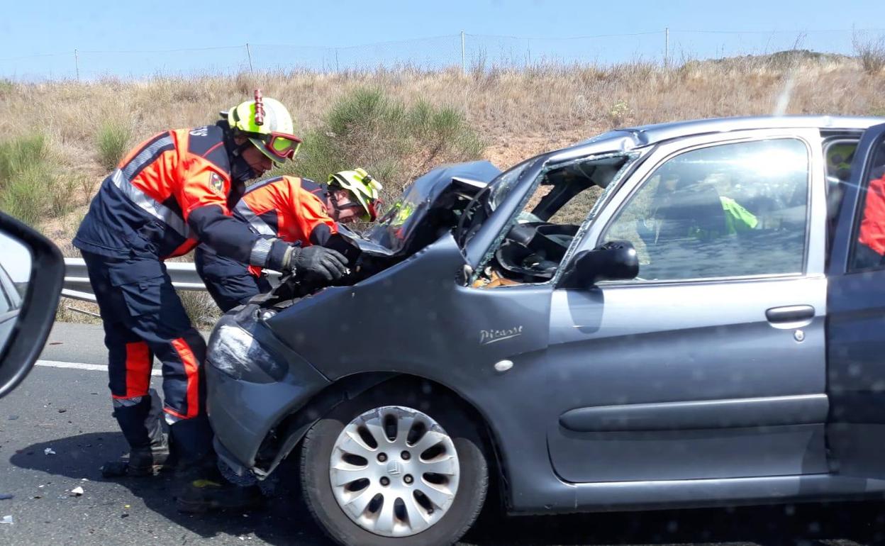 Los bomberos, durante la intervención en el accidente. 