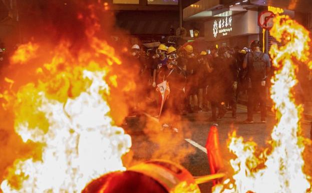 Imagen principal - Avenidas cortadas, choques con la Policía y más de 200 vuelos cancelados en la huelga general de Hong Kong