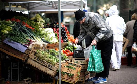 Un jubilado hace la compra en la frutería.