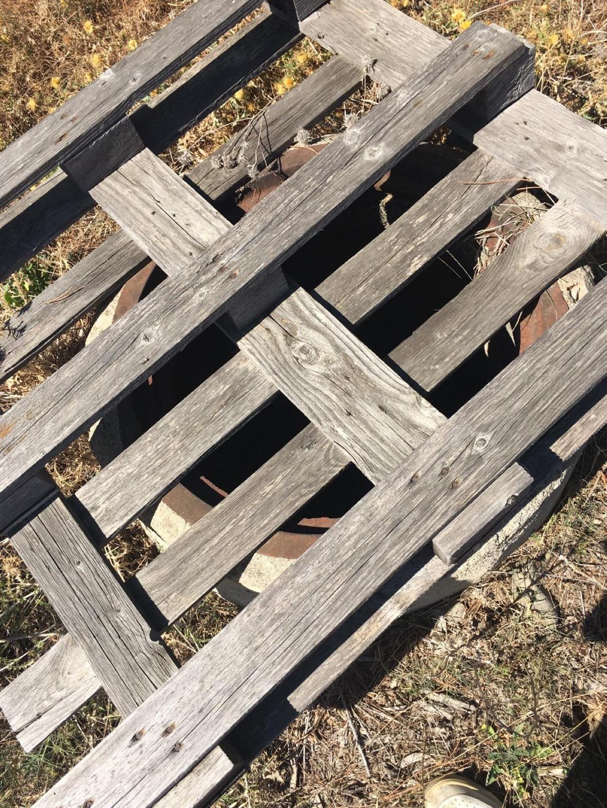 Un palé de madera tapa otro de los pozos. :: msd