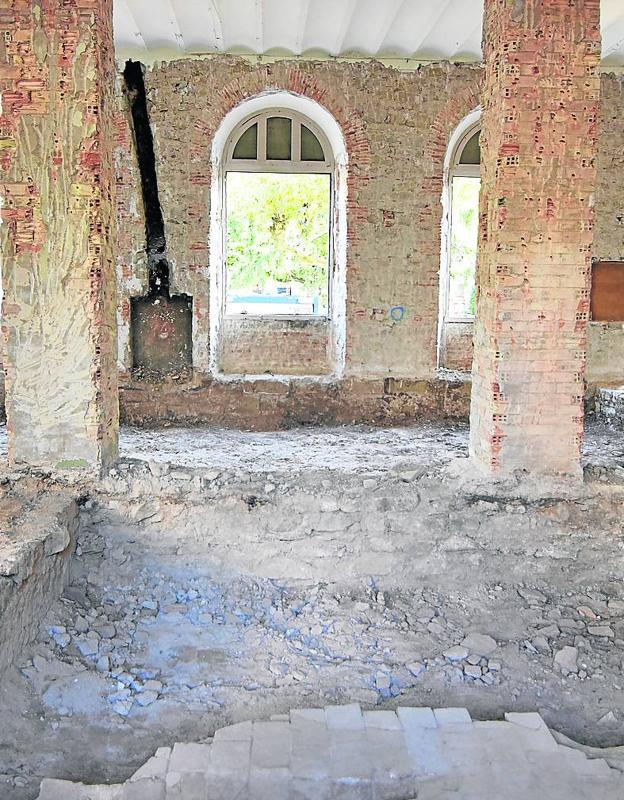 Parte del espacio que otrora ocupaba la biblioteca, que ha sido desmontada y llevada a un taller para su restauración. Puede verse el hueco de la chimenea descubierto en las labores de 'descarnado' de las paredes. Además del suelo y trazas del antiguo convento. 