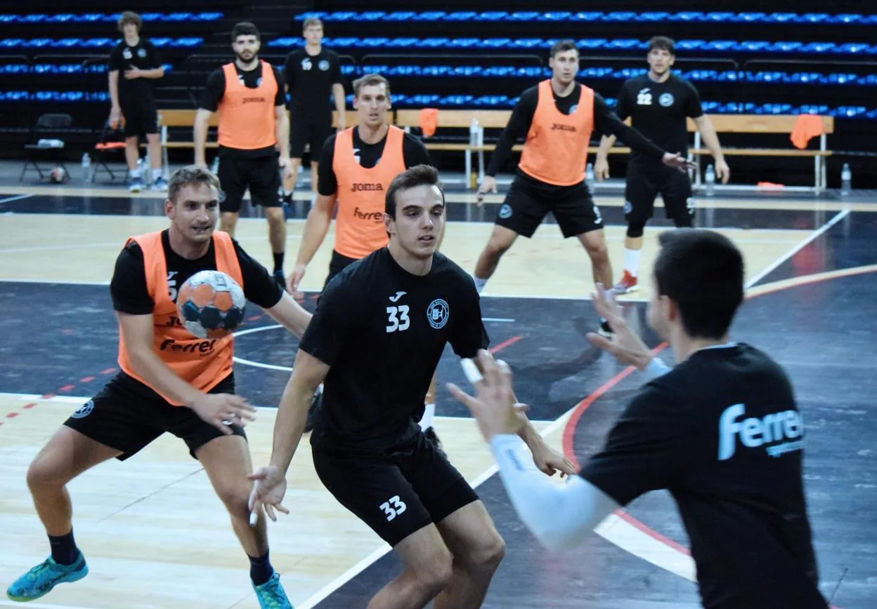Dapiran pasa el balón a David Cadarso (de espaldas) durante un entrenamiento del Ciudad de Logroño en el Palacio. ::