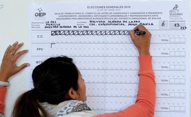Una mujer participa en el escrutinio en una mesa electoral durante las elecciones presidenciales en La Paz (Bolivia).