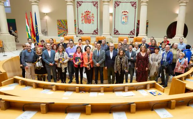 Josefina Rodríguez posa con mimebros de ARPANIH y de las distintas formaciones políticas en el hemiciclo del Parlamento de La Rioja
