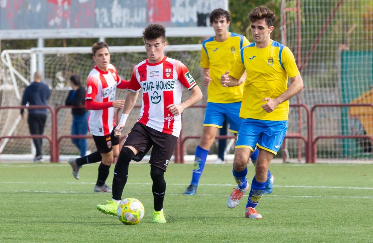 El jugador de la UDL Lapeña controla el balón. 