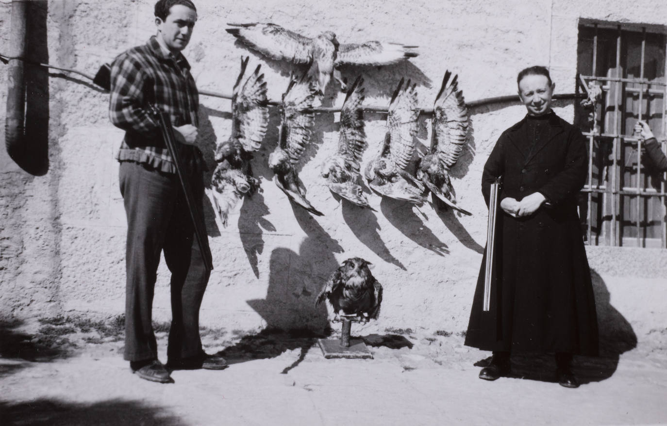 Un cura, escopeta en mano, junto a varias águilas abatidas en 1940