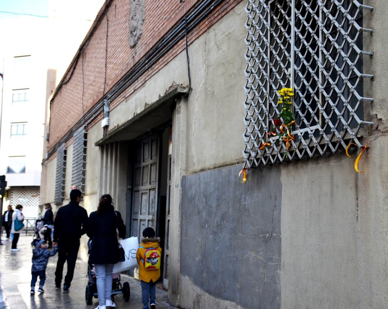 Flores y lazos con la bandera de España, en el antiguo cuartel. 