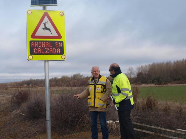 Dos técnicos conversan junto a la señal con sensores instalada en la CL-615, en Castilla y León. 