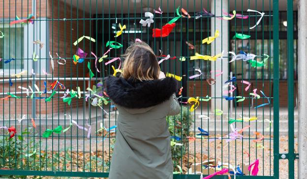 Una mujer, el pasado noviembre colocando lazos de apoyo en la valla del Vicente Ochoa. :: sonia tercero