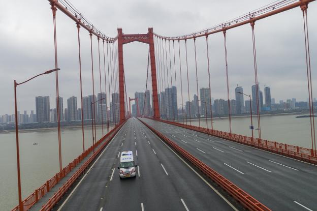 Una ambulancia solitaria cruza el puente de Wuhan, en una fotografía del pasado lunes. :: efe