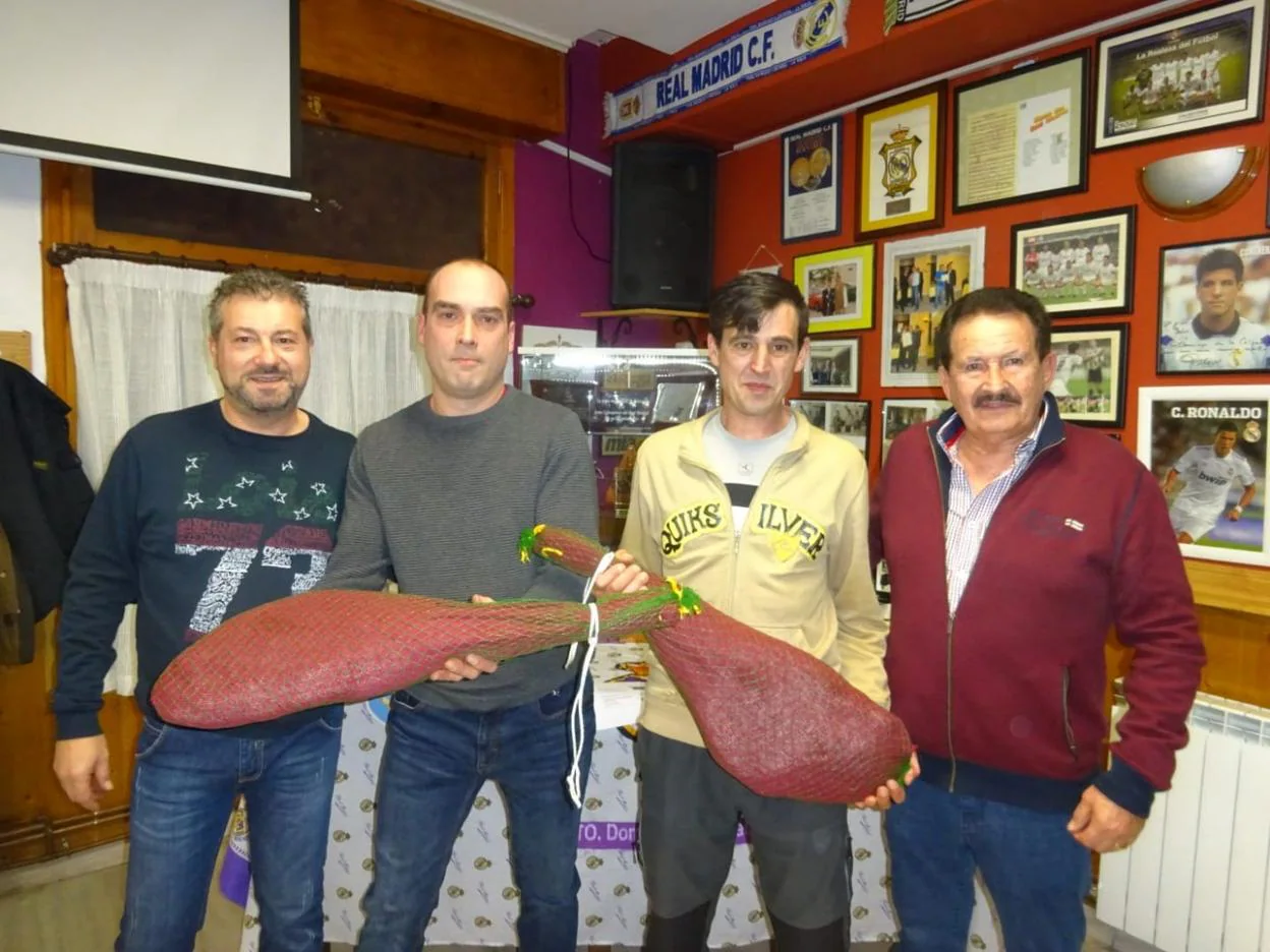 Los ganadores, con el presidente de la peña y el donante de los jamones. 