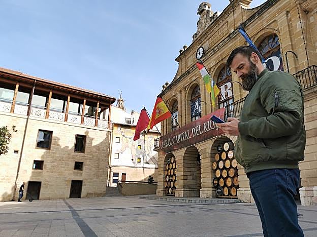 Fidel Muñoz visualiza su app 'Haro monumental' mientras se encuentra junto al Ayuntamiento jarrero, en la plaza de la Paz. 