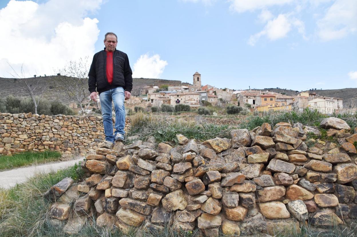 Ildefonso Fernández Muñoz, sobre la pared de una era con Valdemadera al fondo. 