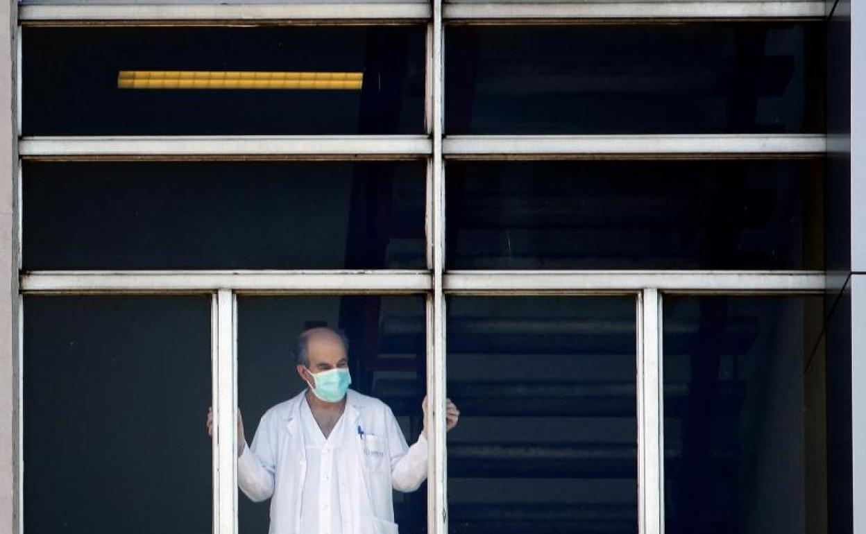 Un sanitario se asoma a la ventana en el Hospital Universitario de A Coruña. 