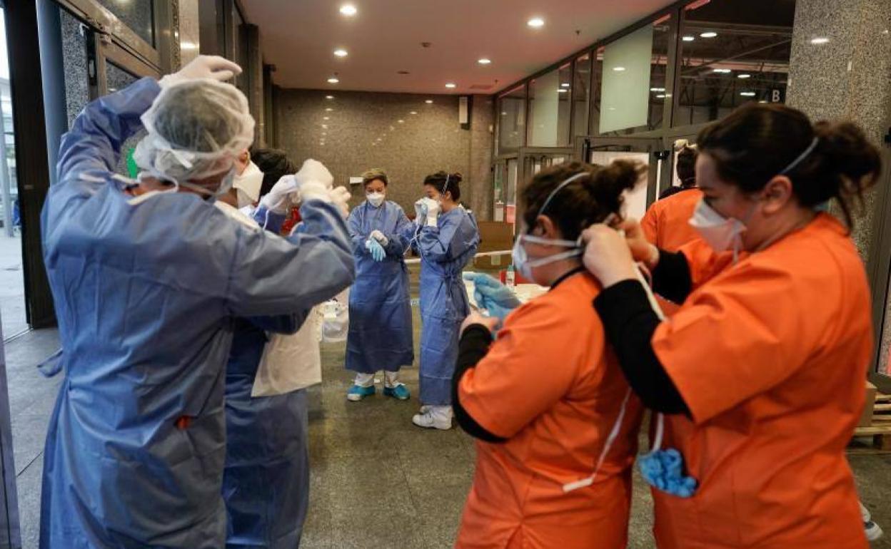 Personal sanitario colocándse los equipos de protección antes de entrar en el hospital provisional de IFEMA, en Madrid.