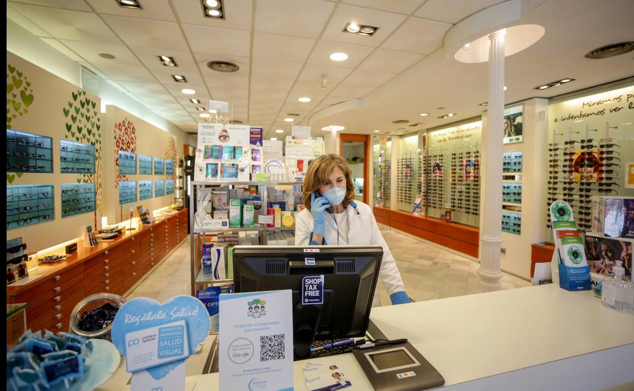 Una óptica habla por teléfono en su tienda de Alcalá de Henares (Madrid).