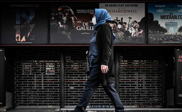 Una mujer pasa frente a un cine de París cerrado el pasado 20 de abril.