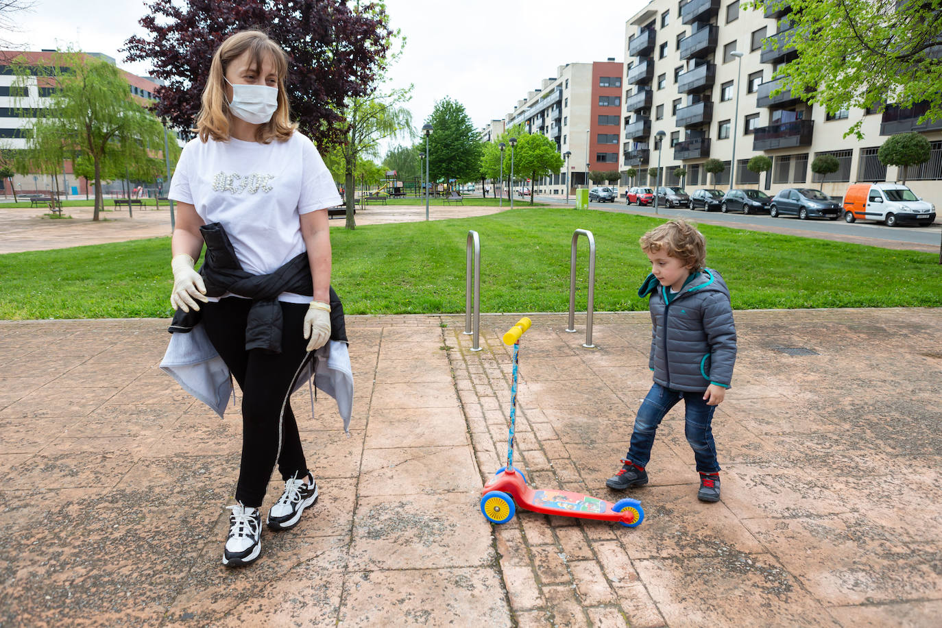 Una madre y su hijo juegan en una zona verde.