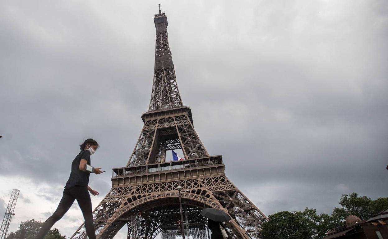 Una mujer hace este domingo ejercicio a los pies de la Torre Eiffel.