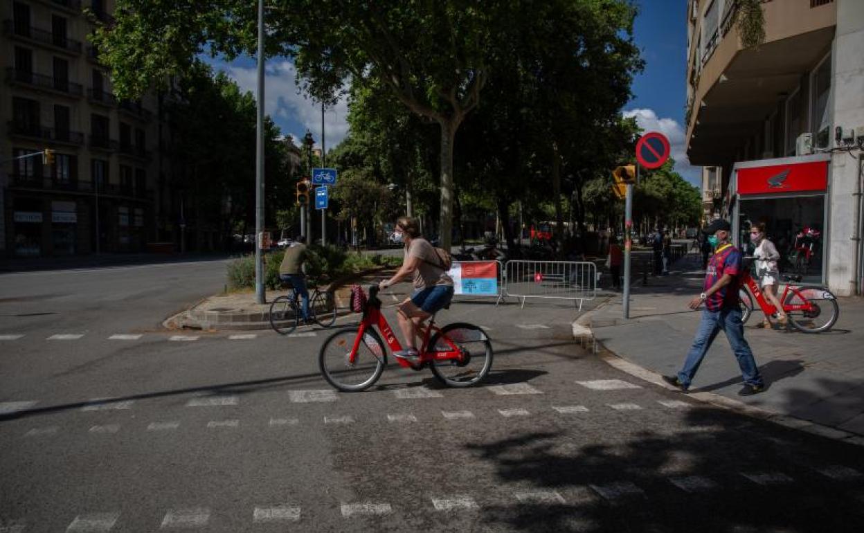 Transeúentes pasan al lado de las vallas instaladas para cortar el tráfico lateral en Barcelona 