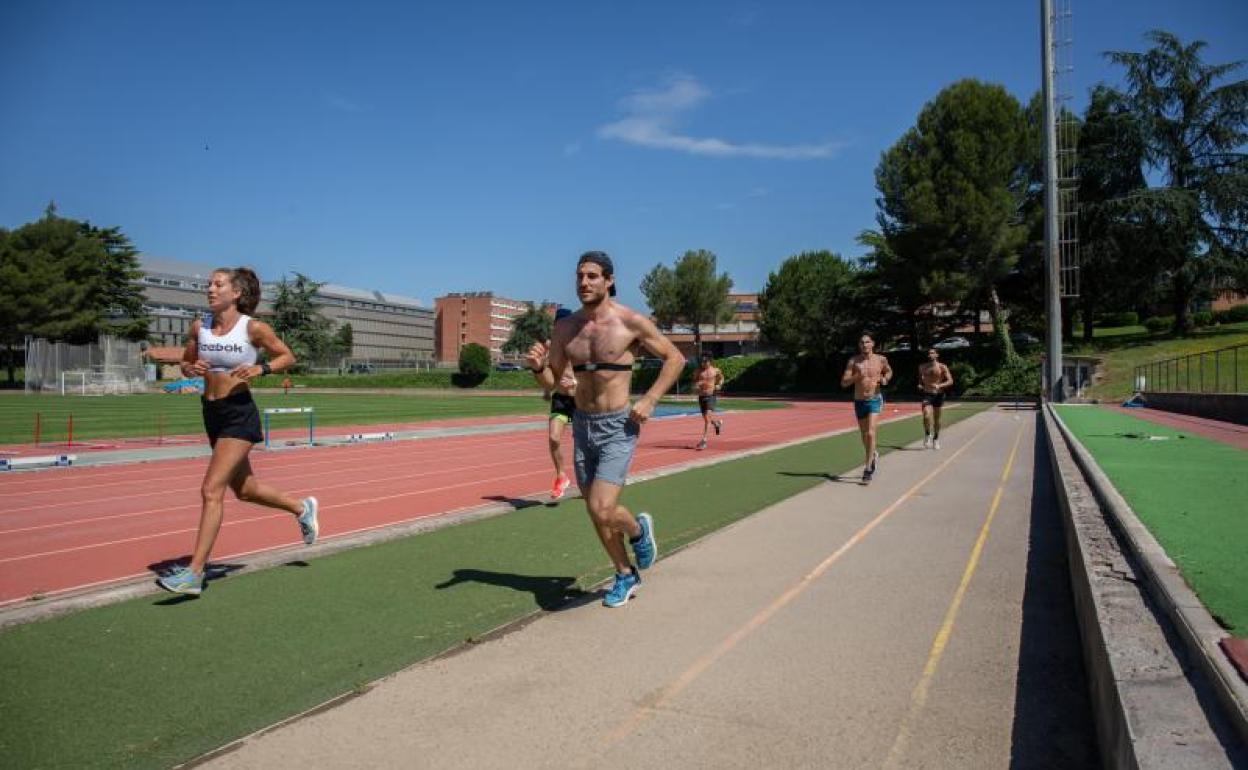 Varios deportistas corren por una pista de atletismo tras la reapertura parcial del CAR de San Cugat. 