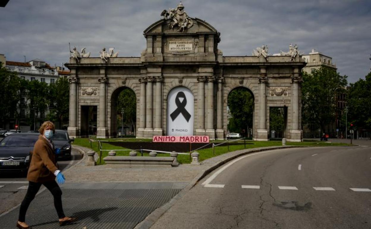 Un peatón a su paso por la madrileña puerta de Alcalá.