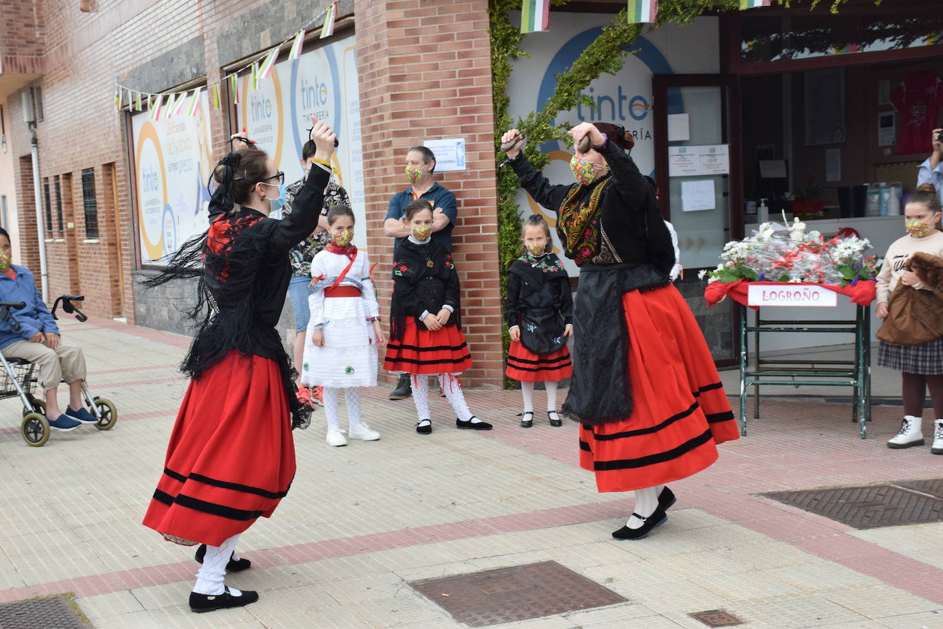 Danzas y flores en la calle por el día del patrón