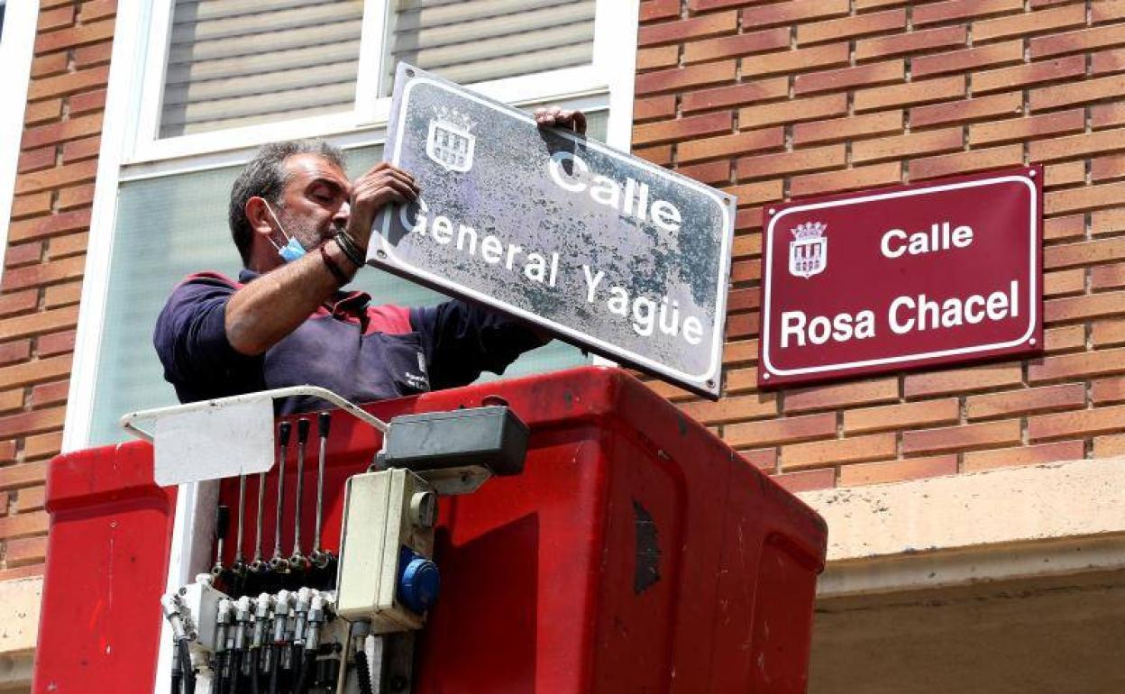 Un operario municipal retira el cartel de General Yagüe. 