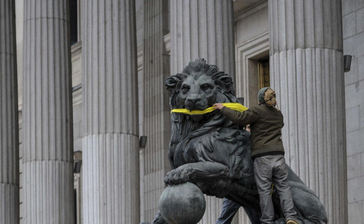 Un activista 'amordaza' a uno de los leones de las Cortes en 2014. 