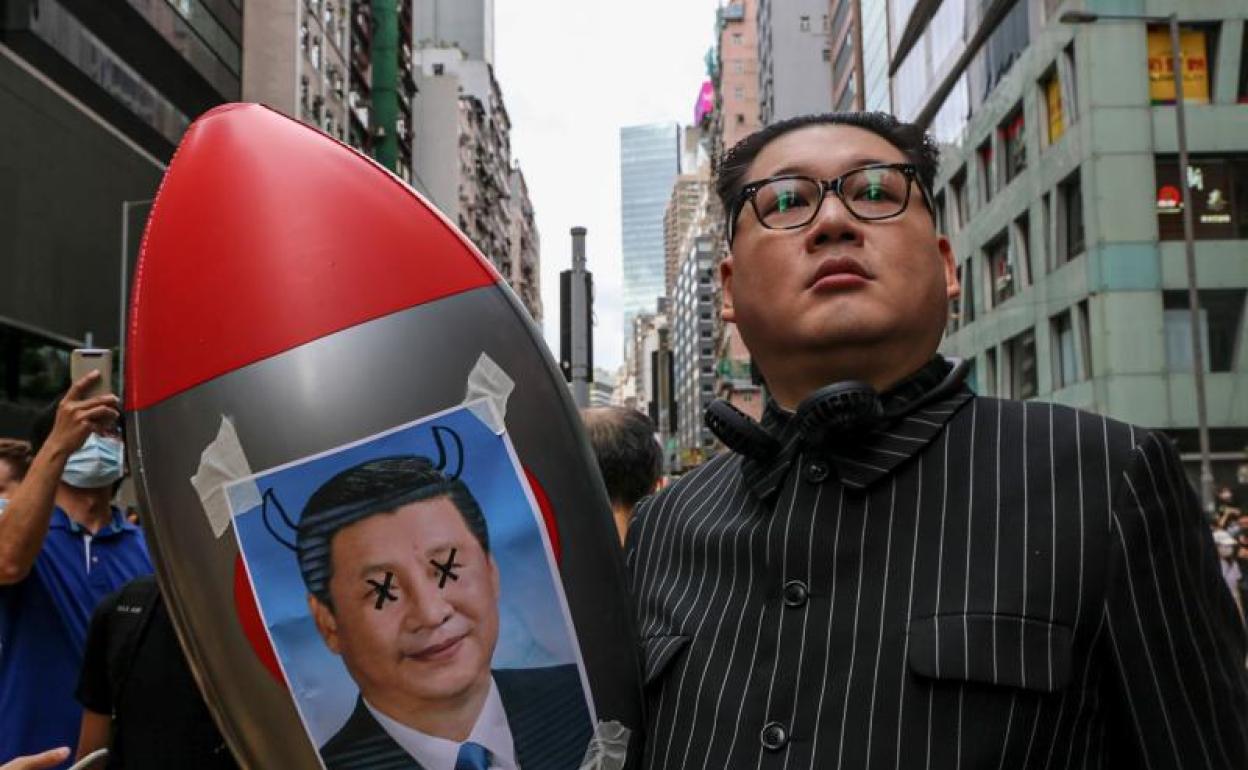 Un manifestante disfrazado de Kim Jung Un con un misil con la imagen del presidente chino, Xi Jinping, durante una protesta.