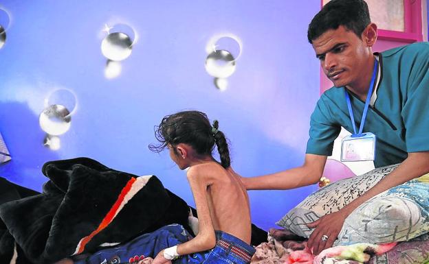 Un médico ausculta a una niña de 11 años en un hospital de Yemen.